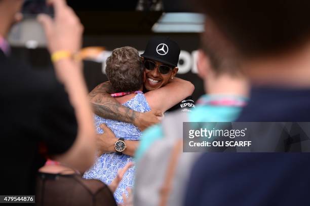 Mercedes AMG Petronas F1 Team's British driver Lewis Hamilton hugs his mother Carmen Larbalestier after winning the British Formula One Grand Prix at...
