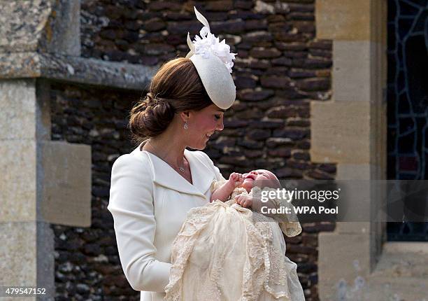 Catherine, Duchess of Cambridge, carries Princess Charlotte of Cambridge as they arrive at the Church of St Mary Magdalene on the Sandringham Estate...