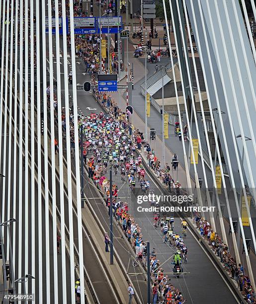 The pack rides on the Erasmusbrug in Rotterdam, during the 166 km second stage of the 102nd edition of the Tour de France cycling race on July 5...