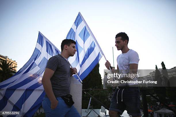 People begin to gather in a square, waiting for the official result after polls closed in the Greek austerity referendum on July 5, 2015 in Athens,...