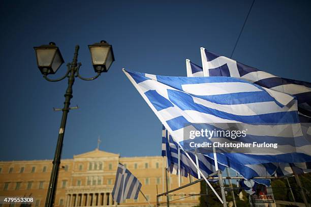 The sun sets over the Greek parliament after the polls closed in the Greek austerity referendum and people are begining to gather in the squares of...