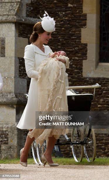 Britain's Catherine, Duchess of Cambridge, carries her daughter, Princess Charlotte of Cambridge after taking her out of a pram as they arrive for...