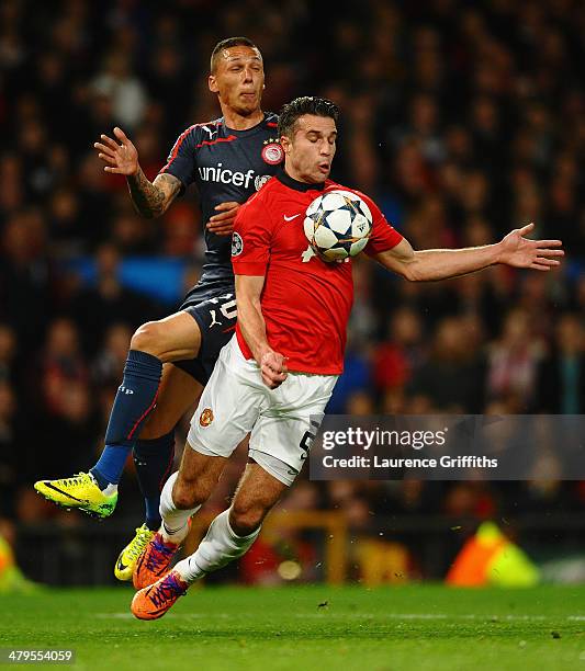 Robin van Persie of Manchester United is fouled in the penalty box by Jose Holebas of Olympiacos during the UEFA Champions League Round of 16 second...