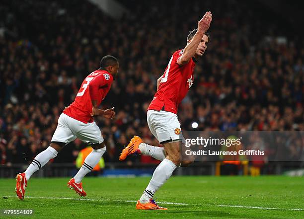 Robin van Persie of Manchester United celebrates scoring the opening goal from a penalty kick during the UEFA Champions League Round of 16 second...