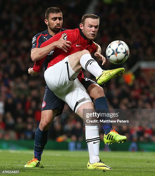 Wayne Rooney of Manchester United in action with Giannis Maniatis of Olympiacos FC during the UEFA Champions League Round of 16 second leg match...