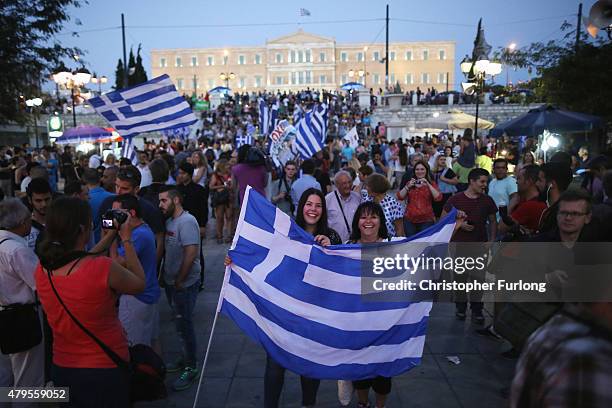 People celebrate in front of the Greek parliament as early opinion polls predict a win for the Oxi, or No, campaign in the Greek austerity...