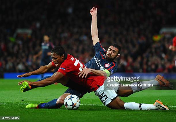 Antonio Valencia of Manchester United tangles with Giannis Maniatis of Olympiacos during the UEFA Champions League Round of 16 second round match...