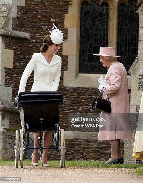 Queen Elizabeth II speaks to Catherine, Duchess of Cambridge, as she pushes in a pram Princess Charlotte of Cambridge at Church of St Mary Magdalene...