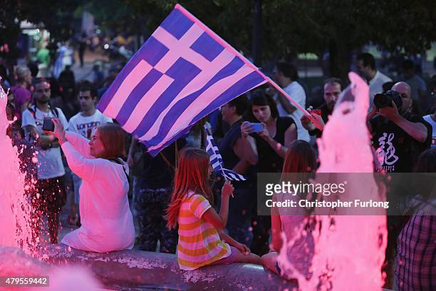 People celebrate in front of the Greek parliament as early opinion polls predict a win for the Oxi, or No, campaign in the Greek austerity referendum...