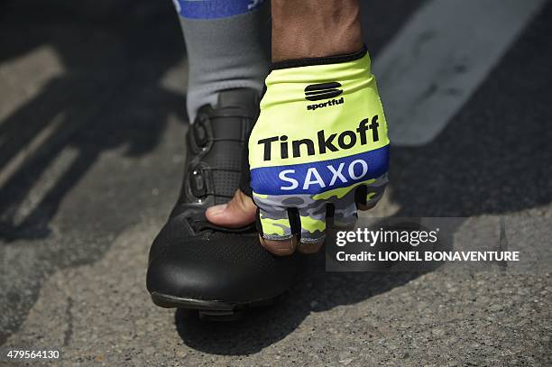 Hand of a rider of Russia's Tinkoff-Saxo cycling team, wearing fingerless gloves, is pictured at the departure village prior to the start of the 166...