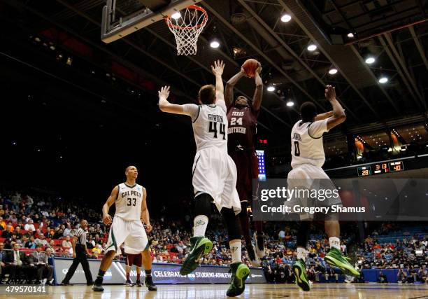 Aaric Murray of the Texas Southern Tigers goes to the basket as Zach Gordon of the Cal Poly Mustangs defends during the first round of the 2014 NCAA...