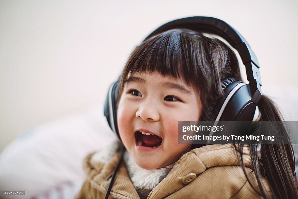 Toddler girl listening to music joyfully
