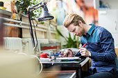 Young handsome man soldering a circuit board