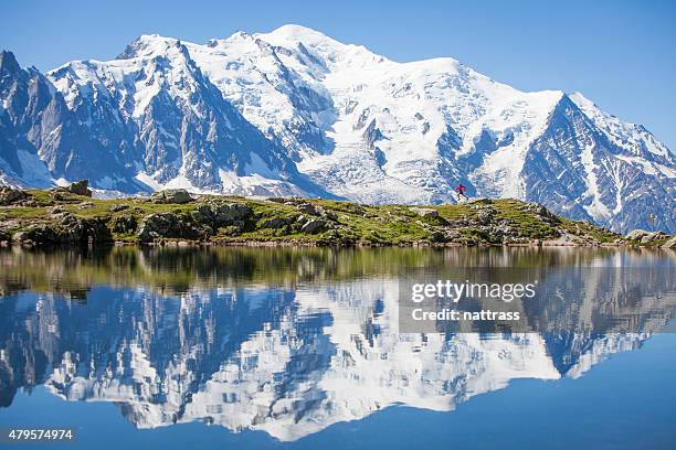 reflection on crystal clear alpine lake, running man - chamonix train stockfoto's en -beelden