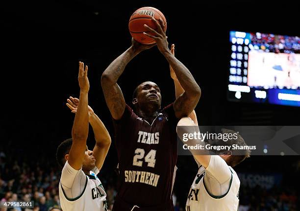 Aaric Murray of the Texas Southern Tigers goes up for a shot as Kyle Odister and Zach Gordon of the Cal Poly Mustangs defend during the first round...