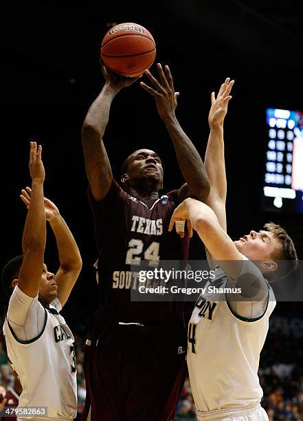 Aaric Murray of the Texas Southern Tigers goes up for a shot as Kyle Odister and Zach Gordon of the Cal Poly Mustangs defend during the first round...