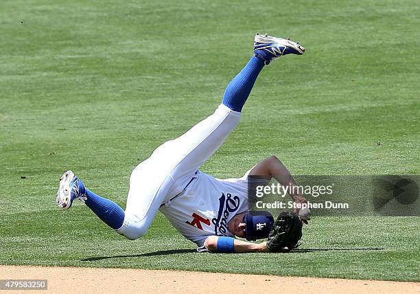 Shortstop Kike Hernadez of the Los Angeles Dodgers flips the ball to second base in an unsuccessfull attempt to get a force out as he rolls after...