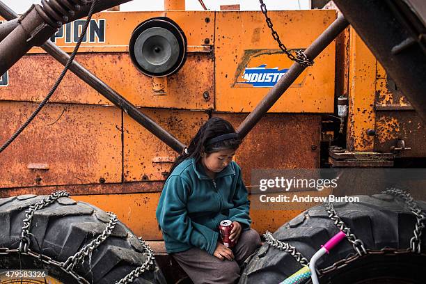 Child relaxes on a piece of machinery during Fourth of July celebrations on July 4, 2015 in Newtok, Alaska. Newtok is one of several remote Alaskan...