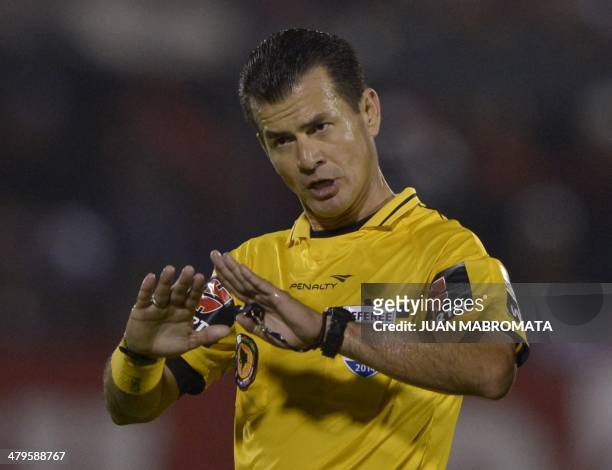 Ecuadoran referee Carlos Vera gestures during the Copa Libertadores 2014 group 6 football match between Argentina's Newell's Old Boys and Brazil's...