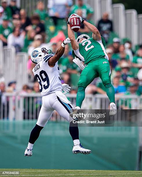 Ryan Smith of the Saskatchewan Roughriders goes up to make a spectacular catch in front of Matt Black of the Toronto Argonauts in the game between...