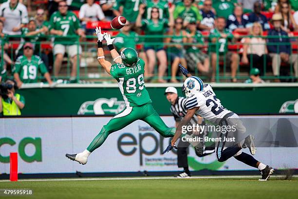 Chris Getzlaf of the Saskatchewan Roughriders catches a touchdown behind Vincent Agnew of the Toronto Argonauts in overtime in the game between the...