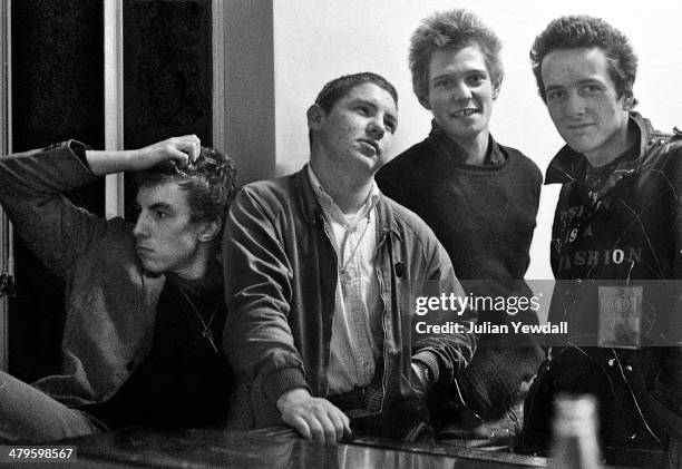 Singer Vic Godard, of Subway Sect, their roadie Barry Auguste, with bassist Paul Simonon and singer Joe Strummer of 'The Clash', backstage at a...