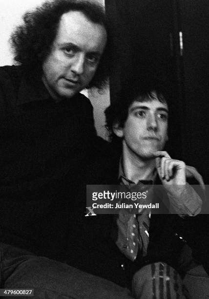 English record producer and manager Guy Stevens and guitarist Mick Jones of British punk group The Clash, backstage at a concert at the Royal College...