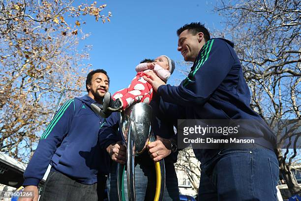 Ben Smith of the Highlanders sits his daughter upon the trophy while Nasi Manu looks on during a street parade to celebrate the Highlanders Super...