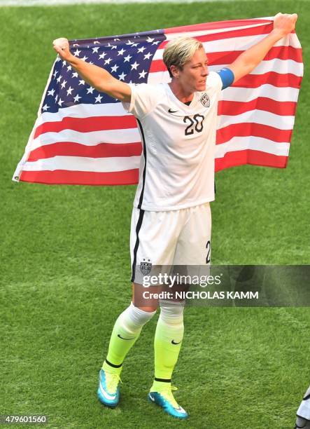 The USA's Abby Wambach celebrates, holding the US national flag, after defeating Japan in the 2015 FIFA Women's World Cup final at BC Place Stadium...