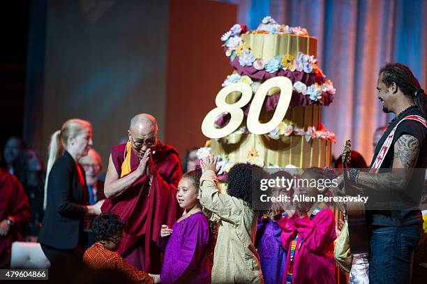 His Holiness the Dalai Lama and recording artist Michael Franti celebrate onstage during His Holiness the 14th Dalai Lama's 80th birthday and Global...