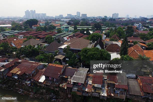 Shanty houses stand perched on stilts along a river in this aerial photograph taken in Jakarta, Indonesia, on Tuesday, June 23, 2015. Having watched...