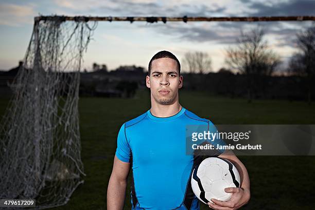 mixed race male with football under arm - want stock pictures, royalty-free photos & images