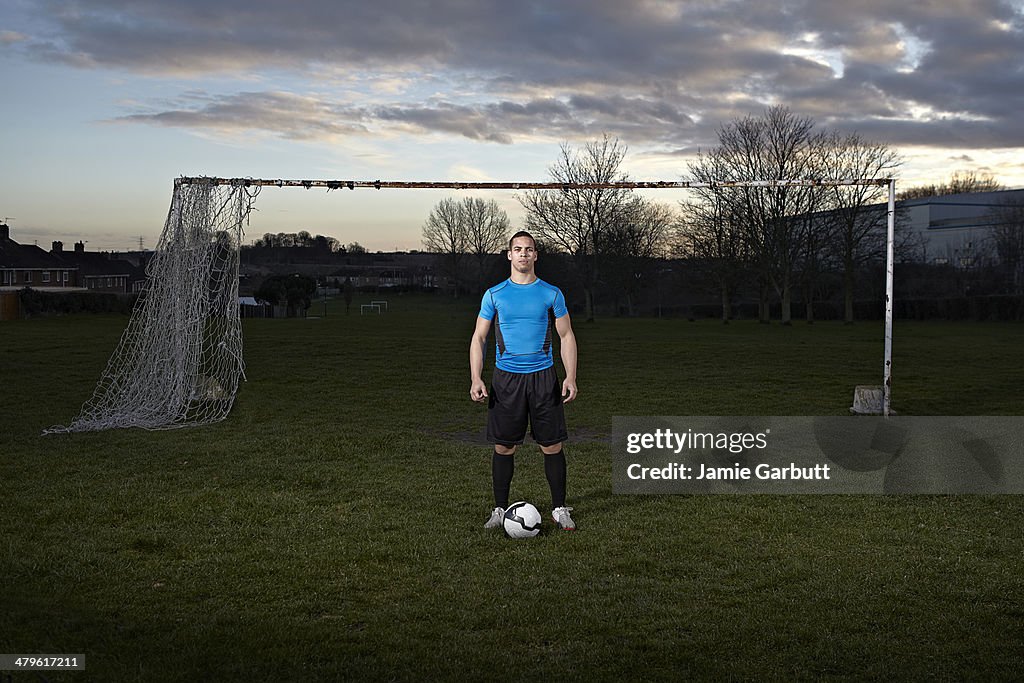 Mixed race male with a football at his feet