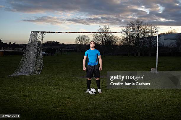 mixed race male with a football at his feet - football player standing stock pictures, royalty-free photos & images