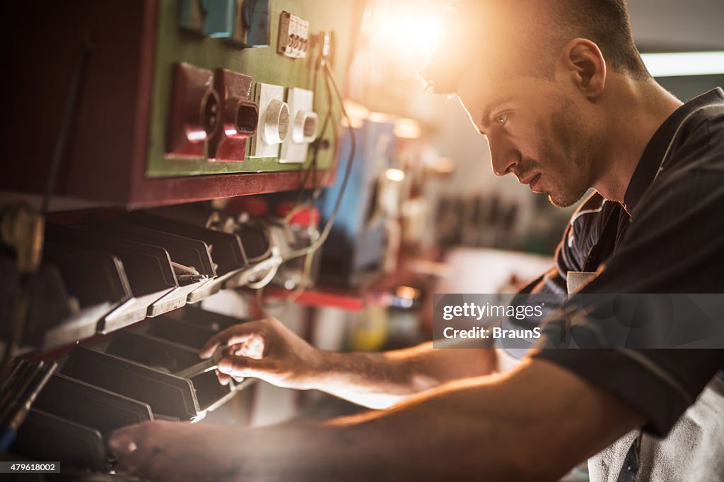 Young repairman choosing the right tool in a workshop.