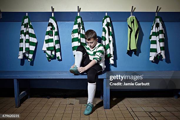 a child tying his shoelaces before a match - soccer boot stock pictures, royalty-free photos & images