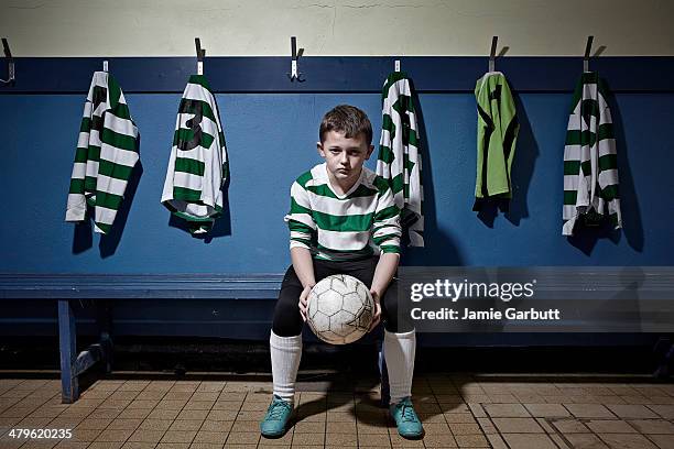 a child holding a soccer ball looking determined - jersey england foto e immagini stock