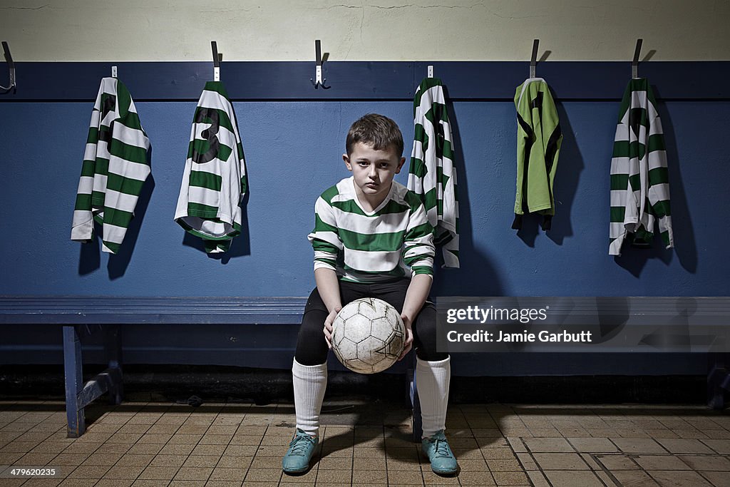 A child holding a soccer ball looking determined