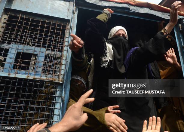 An activist from the Muslim Khawateen Markaz organisation shouts anti-Indian slogans from inside a police vehicle during a protest in Srinagar on...
