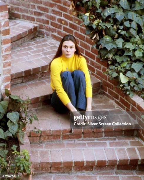 American actress Kate Jackson sitting on a flight of garden steps, circa 1973.