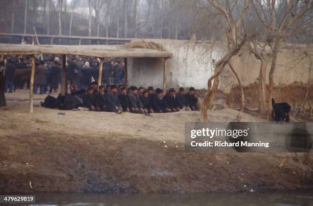 Group of Uighurs praying at the Kashgar Market in Xinjiang. Kashgar is an ancient city that used to be an important Caravanserai on the Silk Road....