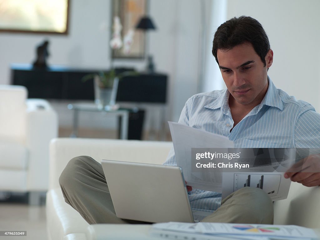 働く男性を自身のノートパソコンを、家でリラックスする