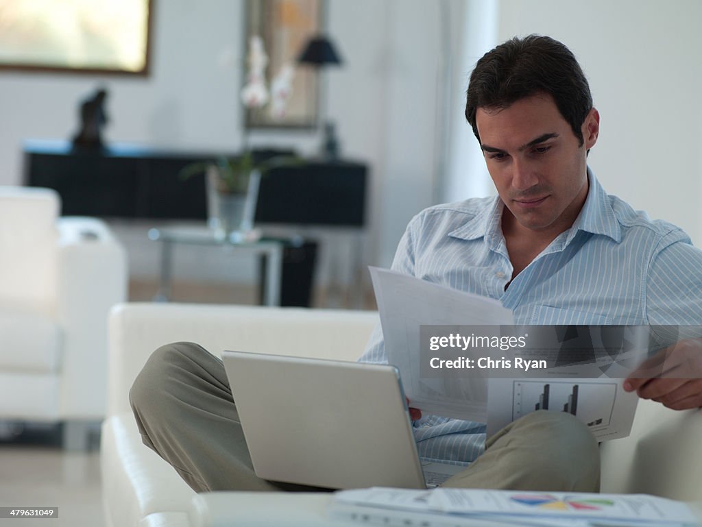 Man working on his laptop while relaxing at home