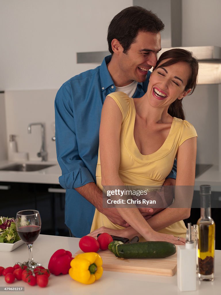 Couple hugging in modern kitchen