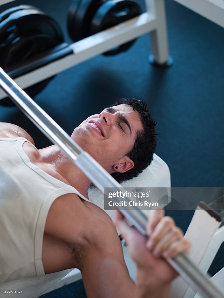 Man on a bench getting ready to lift free weights