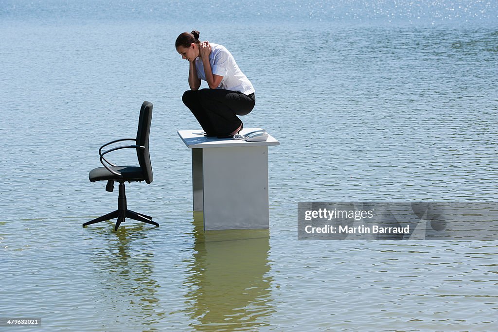 Donna d'affari seduto alla scrivania, guardando acqua
