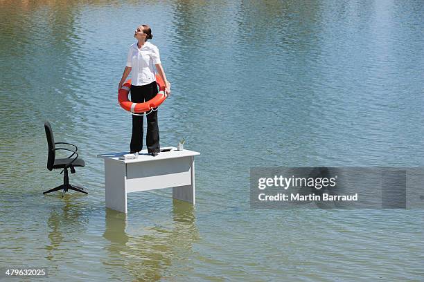 femme d'affaires debout au bureau avec dispositif de flottaison - phénomène climatique extrême photos et images de collection