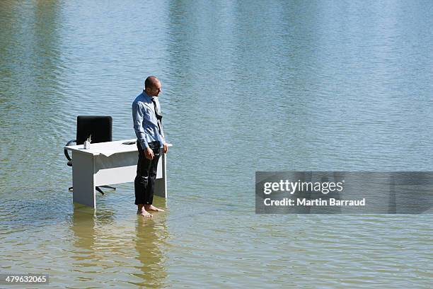businessman standing on water with desk and chair - aerial view desk stock pictures, royalty-free photos & images