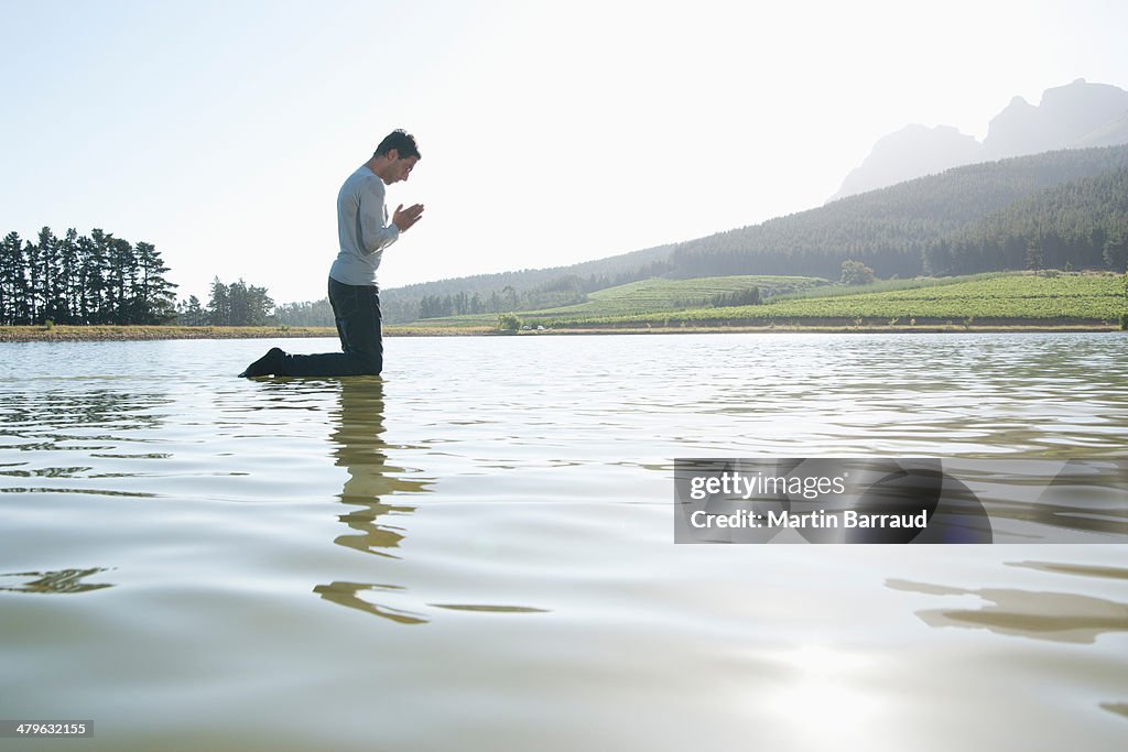 Man kneeling on water praying