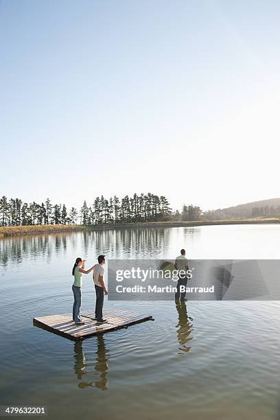 one man standing on water with man and woman watching - embracing change stock pictures, royalty-free photos & images